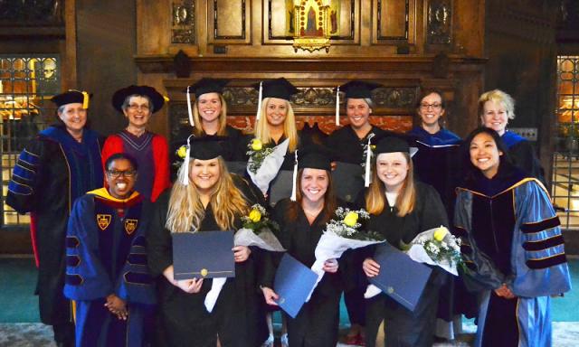 2014 graduates who minored in gender and women's studies pose with faculty.